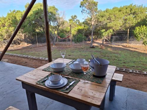 a wooden table with bowls and dishes on it at Coopers Highlands Tree-Top Cabin in Jeffreys Bay