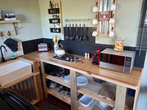 a kitchen with a wooden counter top with a microwave at Coopers Highlands Tree-Top Cabin in Jeffreys Bay