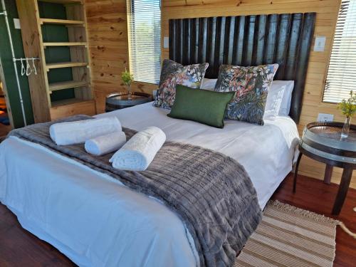 a bedroom with a bed with towels on it at Coopers Highlands Tree-Top Cabin in Jeffreys Bay