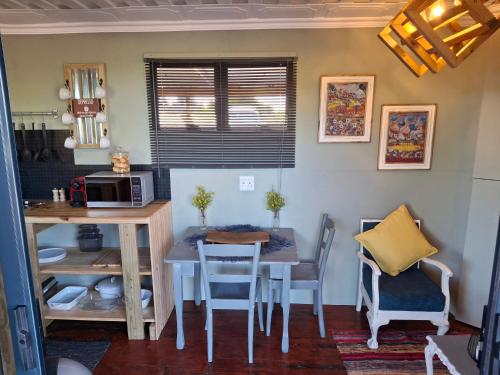 a kitchen with a table and chairs in a room at Coopers Highlands Tree-Top Cabin in Jeffreys Bay