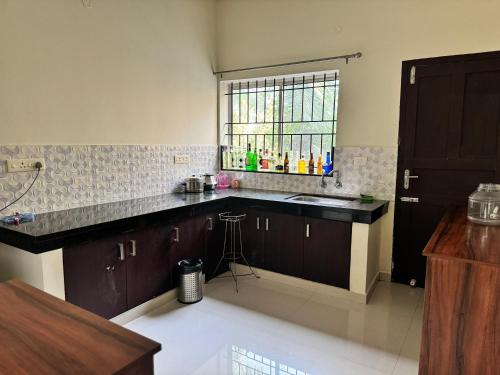 a kitchen with a counter and a sink and a window at Friendsland Home Stay in Ernakulam