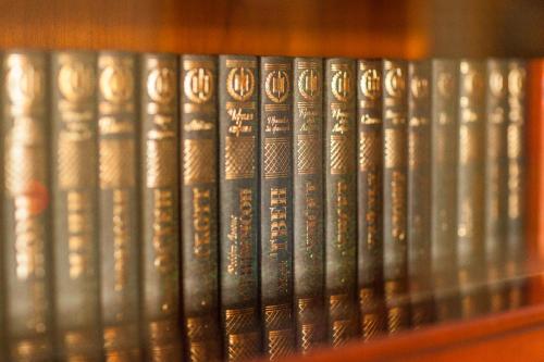 a row of books sitting on a shelf at TB Palace Hotel & SPA in Jūrmala