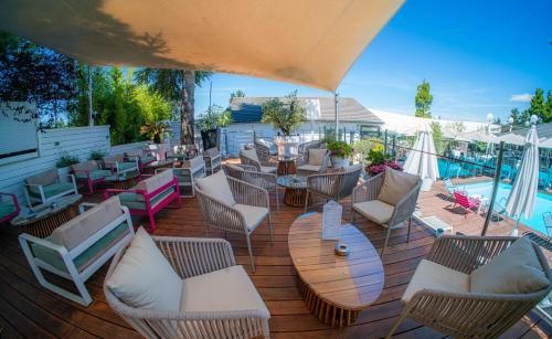 a patio with chairs and tables and a pool at Hotel Du Golf in Saint-Étienne