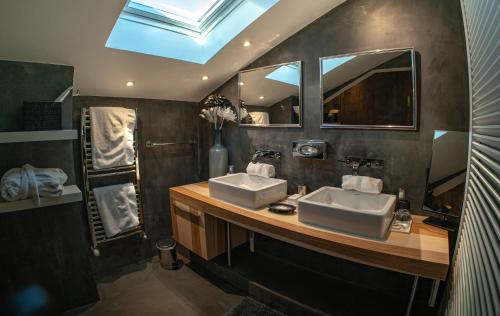 a bathroom with two sinks and a skylight at Hotel Du Golf in Saint-Étienne