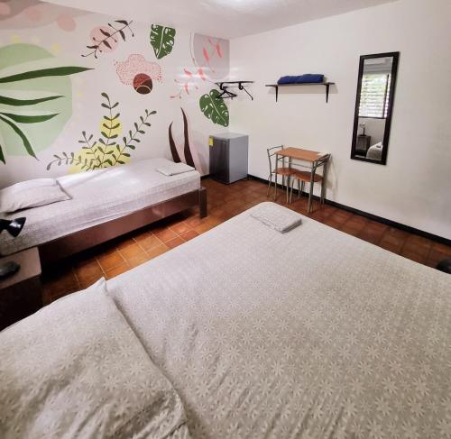 a bedroom with two beds and a wall with plants at Casa Pura Vida Surf Hostel - Tamarindo Costa Rica in Tamarindo