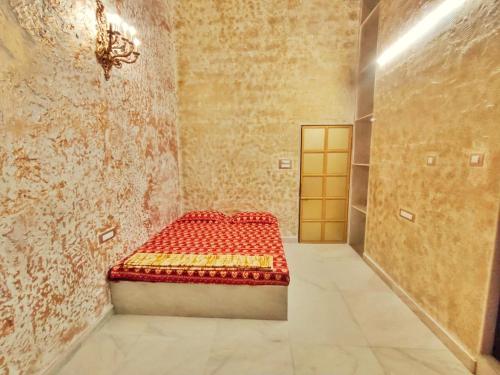 a small room with a red bed in a wall at Wadhwani's Haveli villa in Royal Palms in Mumbai