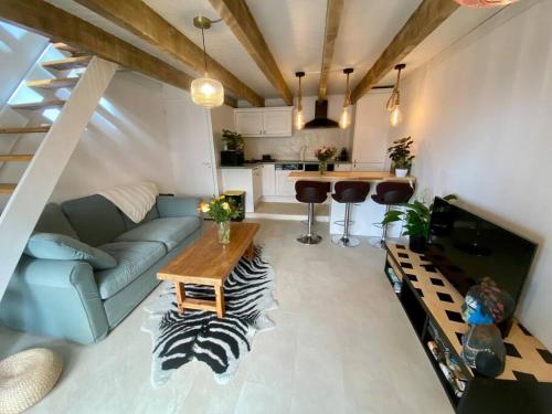 un salon avec un canapé et une table dans l'établissement La maisonnette de Saint-Marc-Sur-Mer, à Brancieux