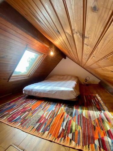 - une chambre avec un lit dans une pièce dotée d'un grand tapis dans l'établissement La maisonnette de Saint-Marc-Sur-Mer, à Brancieux