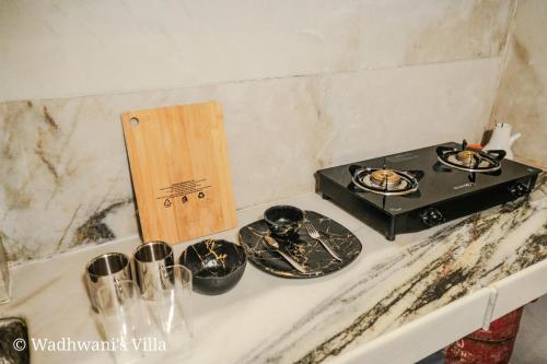 a kitchen counter with a stove and some dishes at Wadhwani's Haveli villa in Royal Palms in Mumbai