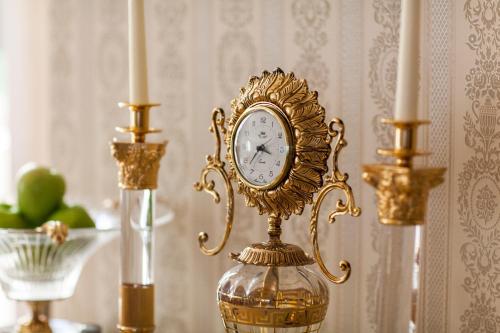 a clock in a vase on a table with candles at TB Palace Hotel & SPA in Jūrmala