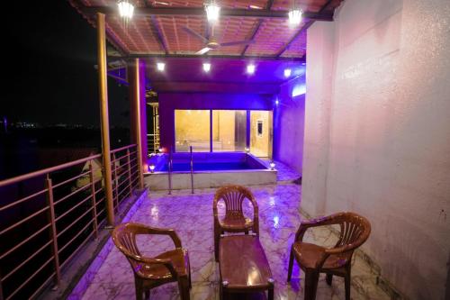three chairs and a tub on a balcony at night at Wadhwani's Haveli villa in Royal Palms in Mumbai
