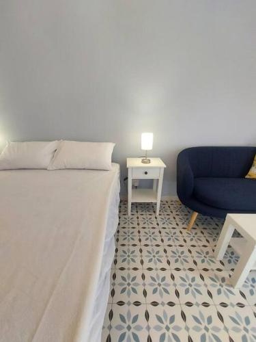 a bedroom with a bed and a blue chair at Studio Suite near Valletta in Il-Furjana