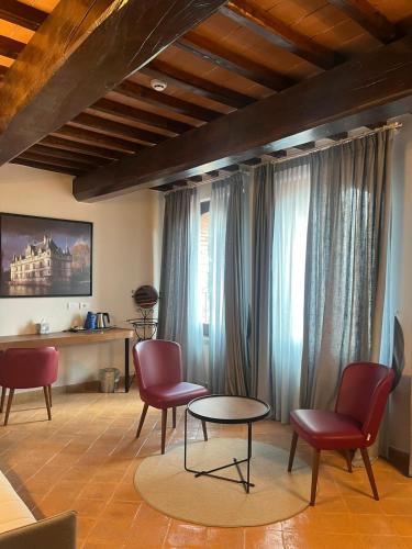 a living room with red chairs and a table at Borgo Di Celle in Città di Castello