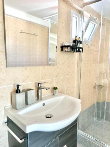 a bathroom with a white sink and a shower at Sunset View Vergas in Kalamata