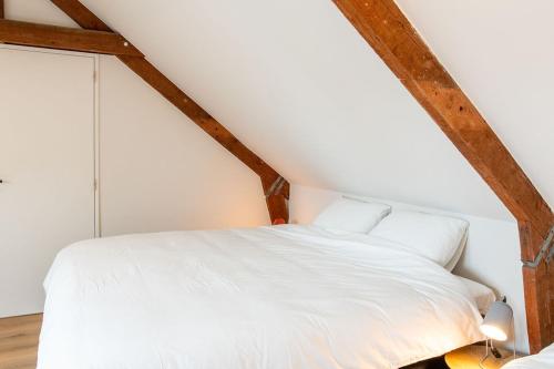 a bedroom with a white bed in a attic at Ruime en Zonnige 5 sterren Vakantiewoning SVN7tien in Doornhoek
