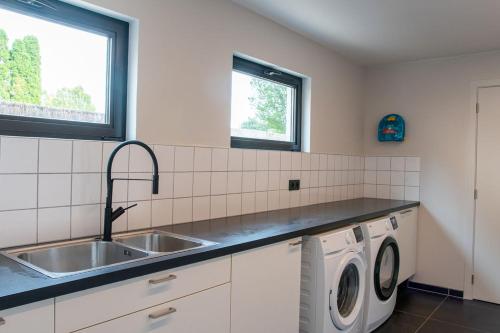 a kitchen with a sink and a washing machine at Ruime en Zonnige 5 sterren Vakantiewoning SVN7tien in Doornhoek