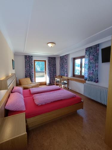a bedroom with two beds and a living room at Jugendgästehaus Hinterronach in Saalbach-Hinterglemm