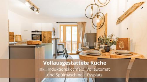 a kitchen and dining room with a table in a room at Chalet WaldHäusl luxuriöse Ferienwohnungen mit Sauna & Whirlpool, Kamin, Balkon oder Terrasse mit Bergblick in Heiligenblut