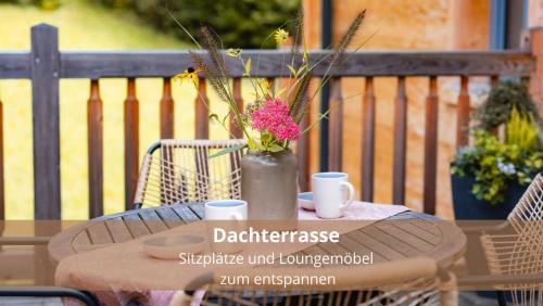 a table with a vase with flowers on it at Chalet WaldHäusl luxuriöse Ferienwohnungen mit Sauna & Whirlpool, Kamin, Balkon oder Terrasse mit Bergblick in Heiligenblut