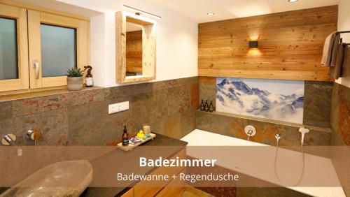 a bathroom with a sink and a bath tub at Chalet WaldHäusl luxuriöse Ferienwohnungen mit Sauna & Whirlpool, Kamin, Balkon oder Terrasse mit Bergblick in Heiligenblut