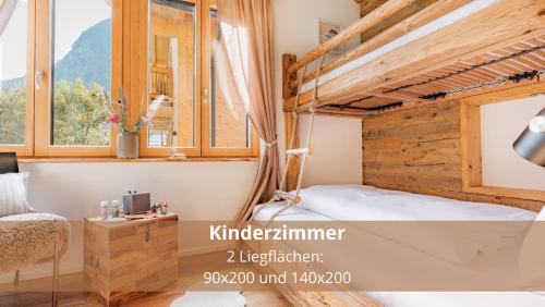 a bedroom with a bunk bed and a window at Chalet WaldHäusl luxuriöse Ferienwohnungen mit Sauna & Whirlpool, Kamin, Balkon oder Terrasse mit Bergblick in Heiligenblut