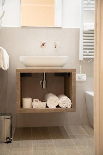 a bathroom with a sink and a shelf with towels at Roxy luxury house Rome in Rome