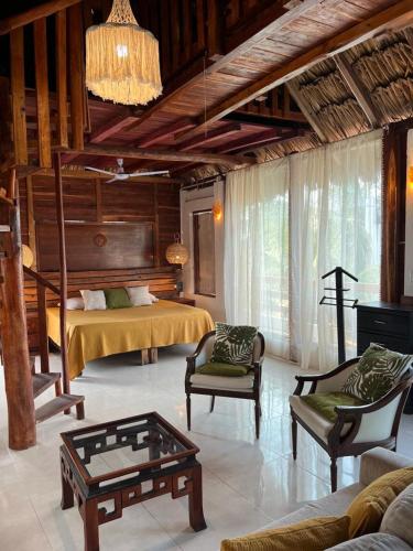 a living room with a bed and a couch and a table at Casa Iguana hotel boutique in El Cuyo