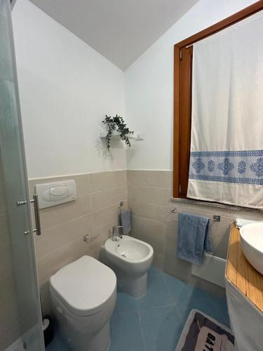 a bathroom with a toilet and a sink at Villa Orsola in Chia