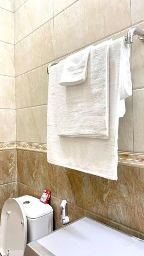 a bathroom with white towels hanging on a towel rack at Teddy Homestay in Makindye