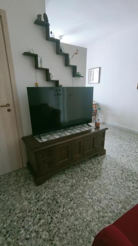 a living room with a tv and a staircase at Luna Normanna in Rutigliano