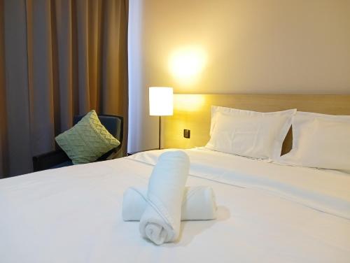 a hotel room with a towel on a bed at The Straits Suites by Ciconia in Melaka