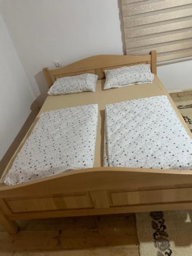 a wooden bed with two pillows on it at Racina Apartmani in Plav