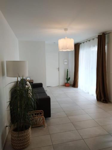 a living room with a couch and a potted plant at Amazing brand new 50 sqm flat - 5min from gondolas in Brides-les-Bains