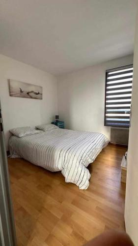 une chambre avec un grand lit avec un plancher en bois dans l'établissement A L AZURA Joli Duplex tout proche plage - Clim Wifi parking - Hameau de la Plage, à Saint-Cyprien