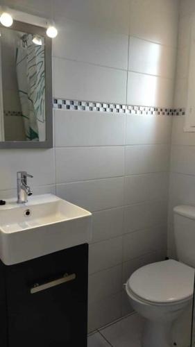 une salle de bain blanche avec un lavabo et des toilettes dans l'établissement A L AZURA Joli Duplex tout proche plage - Clim Wifi parking - Hameau de la Plage, à Saint-Cyprien