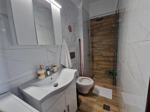 ein Badezimmer mit einem weißen Waschbecken und einer Toilette in der Unterkunft Aigaiou House 2 in Thessaloniki