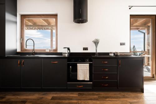 Mokosz في PyzÃ³wka: مطبخ مع دواليب سوداء ومغسلة