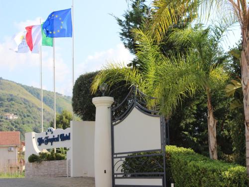 a gate with a sign in front of two flags at Blu Tropical Resort in Zambrone
