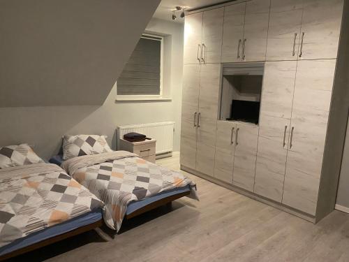 リマノバにあるHoliday home Limanowaのベッドルーム1室(ベッド1台付)、大きなキャビネットが備わります。
