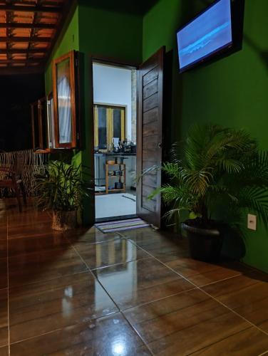 a green room with a door and a plant at Flat de Irinha Moreré in Cayru