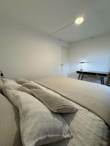 a bed with pillows on it in a room at Private apartment malmö in Malmö