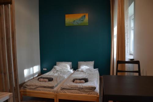 two beds in a room with a green wall at Hotel Mergera in Mērsrags