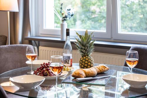a glass table with wine glasses and food on it at have-a-nice-Stay - U-Bahn nach Hamburg 150m- Bäcker & Restaurants 200m - Lidl 800m - Zentrum 1,5km in Ahrensburg