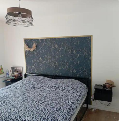 une chambre avec un lit avec une tête de lit noire dans l'établissement Maison de famille proche de la mer, à Lannilis