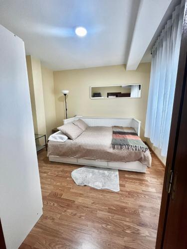 a bedroom with a bed and a wooden floor at DÚPLEX DUQUESA in O Barco de Valdeorras
