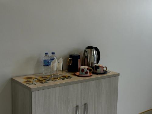 a counter top with a coffee maker and bottles of water at Liora Homestay in Gelioya