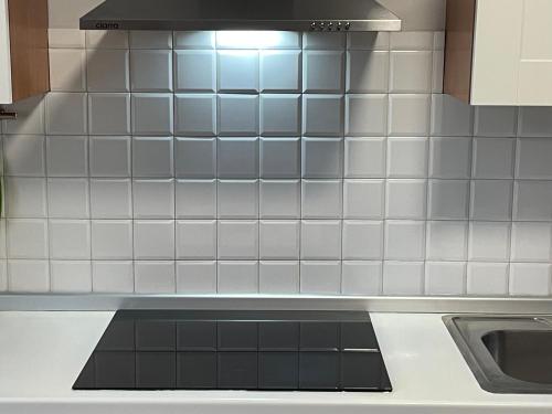 a kitchen with white tiles on the wall at Casa MontOrfano Erbusco in Erbusco