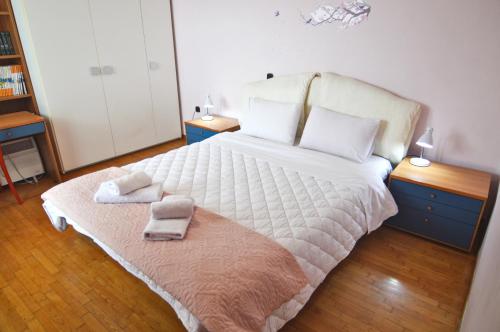a bedroom with a large bed with two towels on it at tania's view in Kastoria