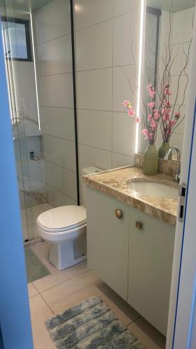 a bathroom with a toilet and a sink and a mirror at Blue Beach Resort Residence Cabedelo-João Pessoa PB AP 2 quartos - 70 m2 in Cabedelo