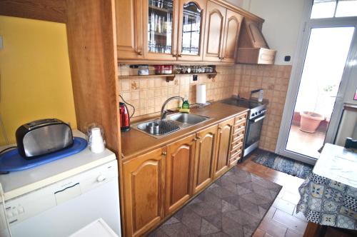 a kitchen with wooden cabinets and a sink at tania's view in Kastoria
